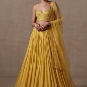 Woman wearing mustard yellow embroidered lehenga for haldi ceremony
